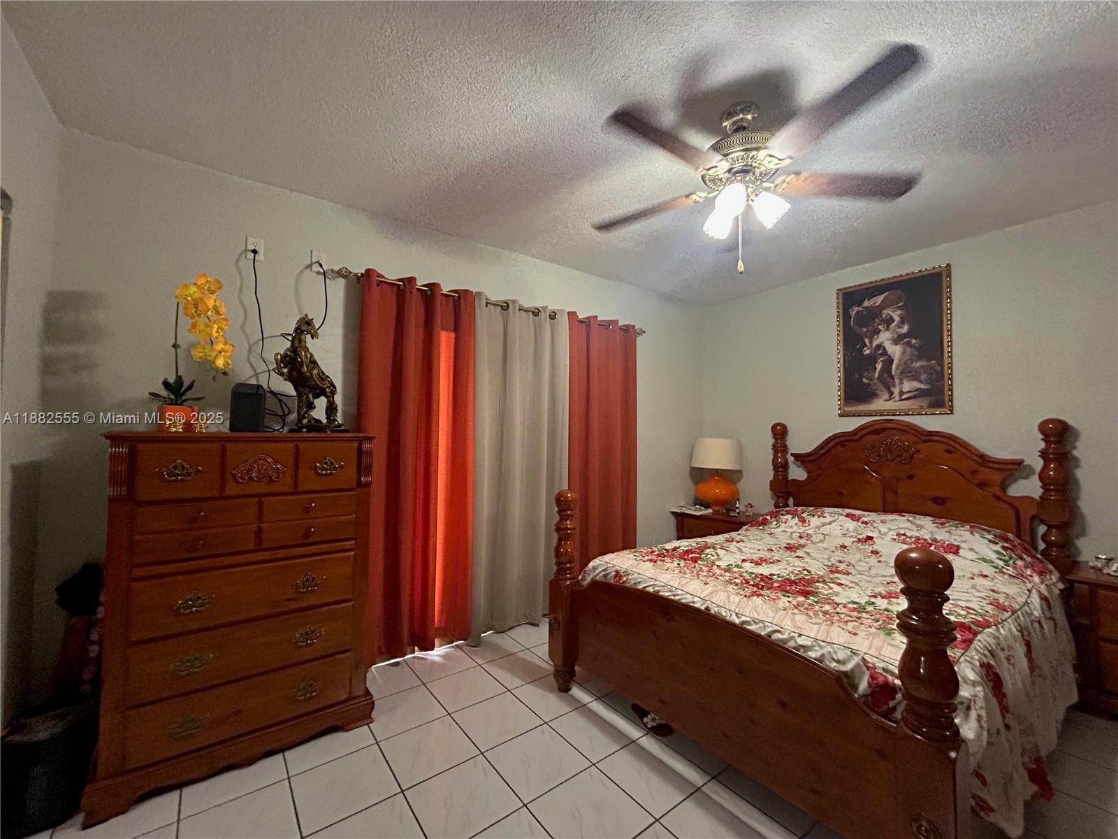460 East 23rd Street, Unit 103 Hialeah, FL 33013 - Photo 13 of 20 a bedroom with a bed and a chandelier