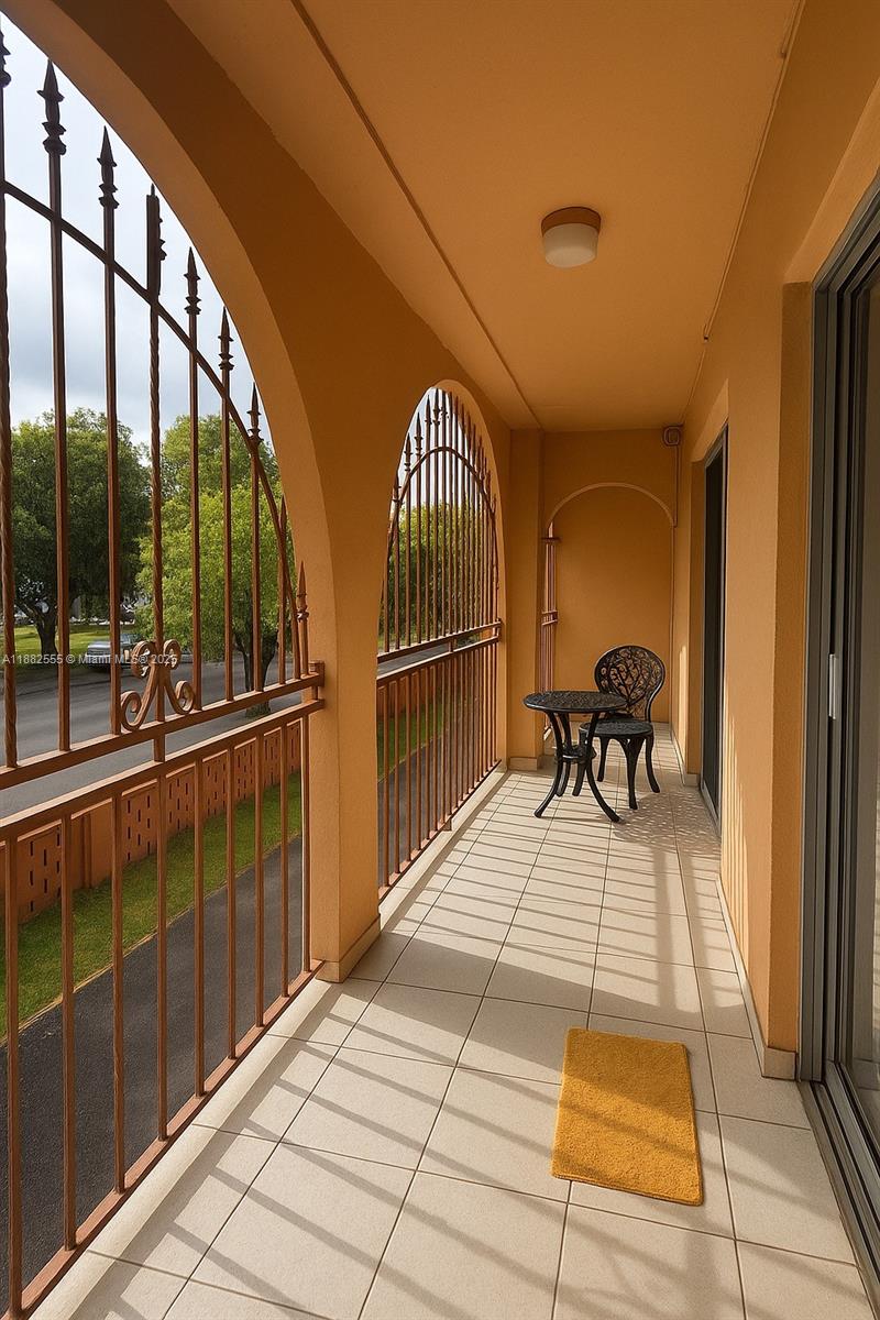 460 East 23rd Street, Unit 103 Hialeah, FL 33013 - Photo 16 of 20 a view of a balcony with chair and floor to ceiling window