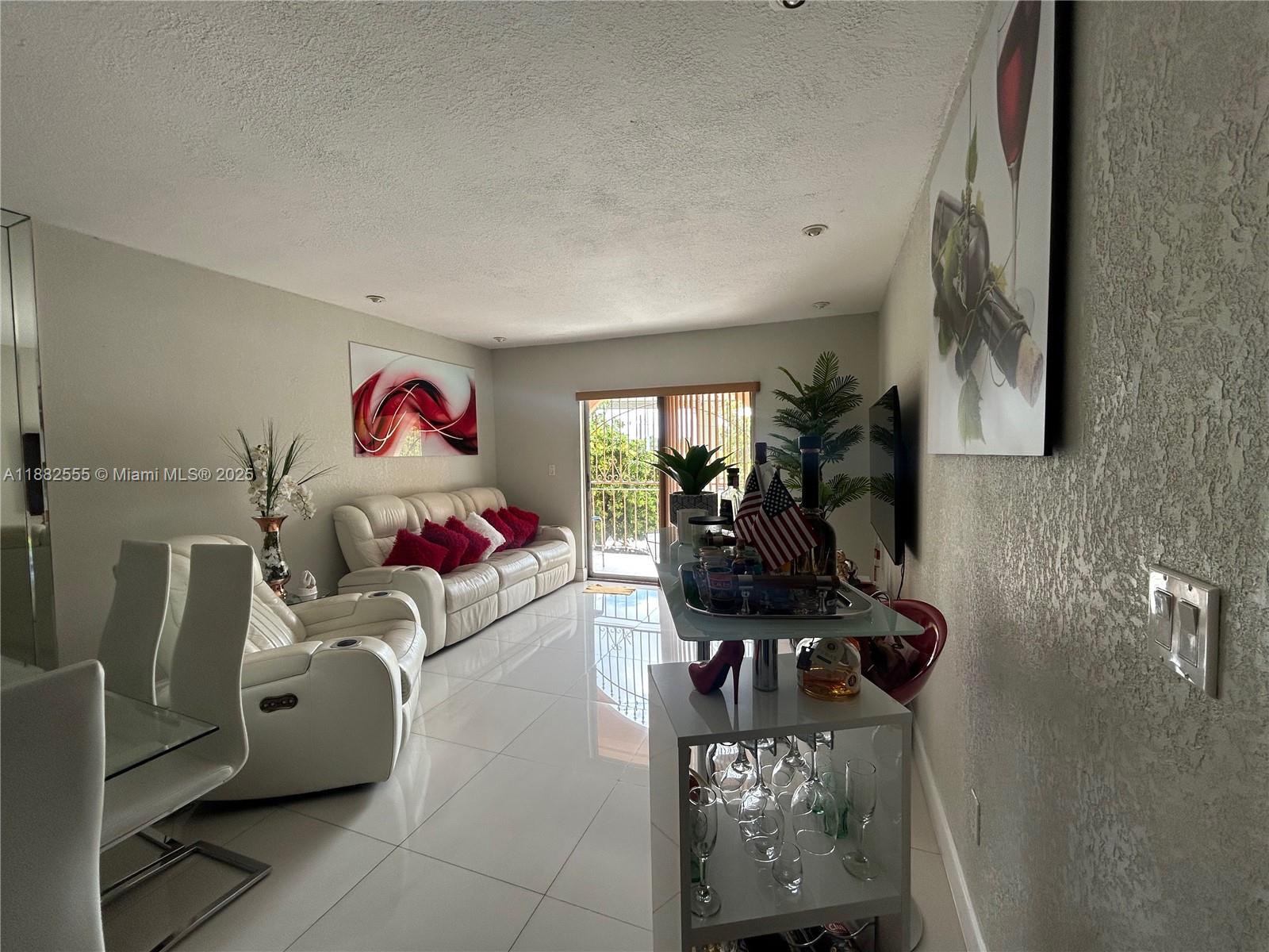 460 East 23rd Street, Unit 103 Hialeah, FL 33013 - Photo 2 of 20 a living room with furniture and a flat screen tv