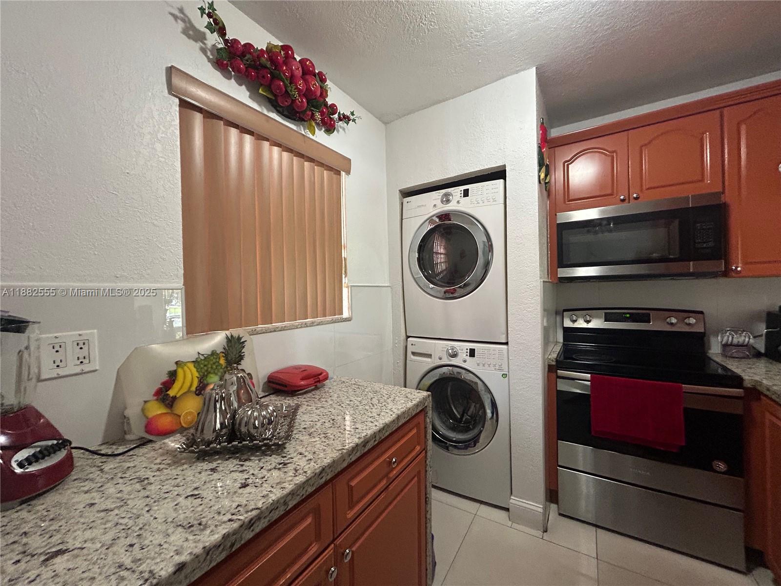 460 East 23rd Street, Unit 103 Hialeah, FL 33013 - Photo 5 of 20 a bedroom with a bed and a washing machine