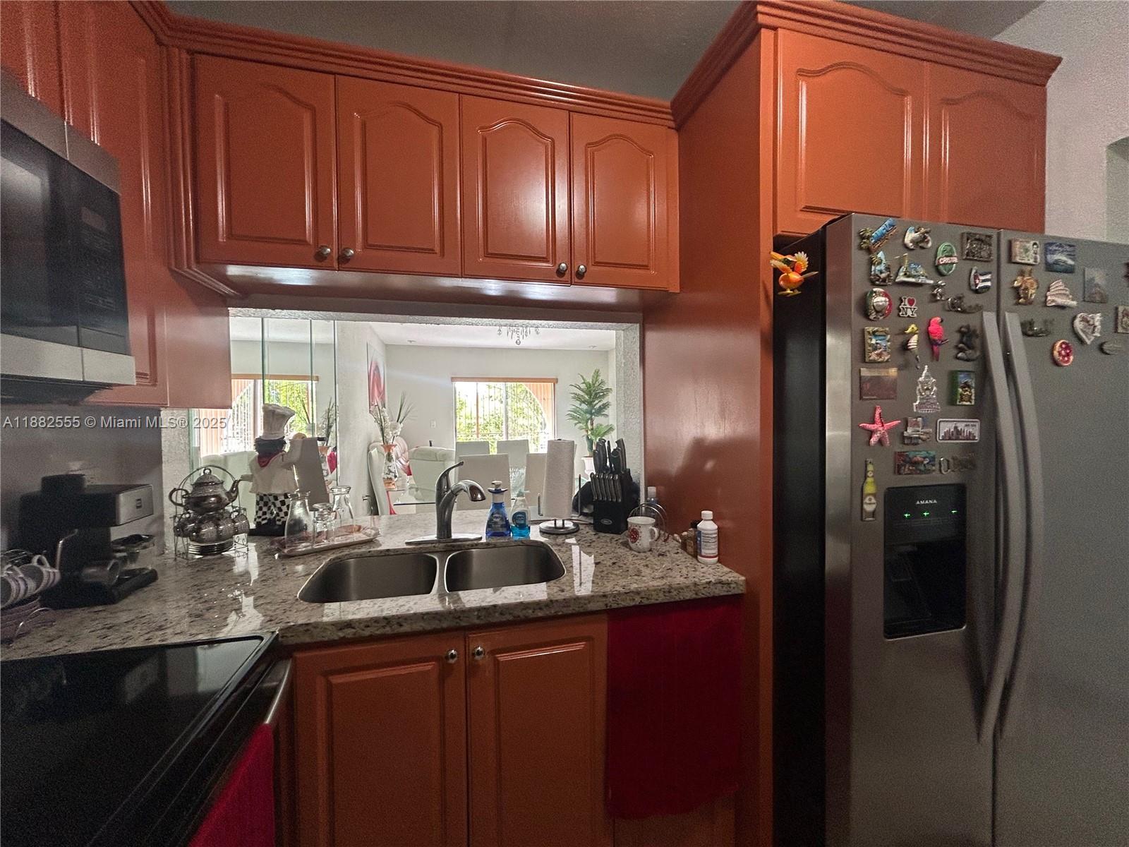 460 East 23rd Street, Unit 103 Hialeah, FL 33013 - Photo 7 of 20 a kitchen with stainless steel appliances granite countertop a refrigerator and a sink