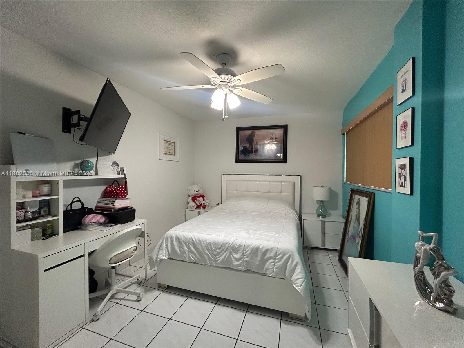460 East 23rd Street, Unit 103 Hialeah, FL 33013 - Photo 8 of 20 a bedroom with a bed and a chandelier