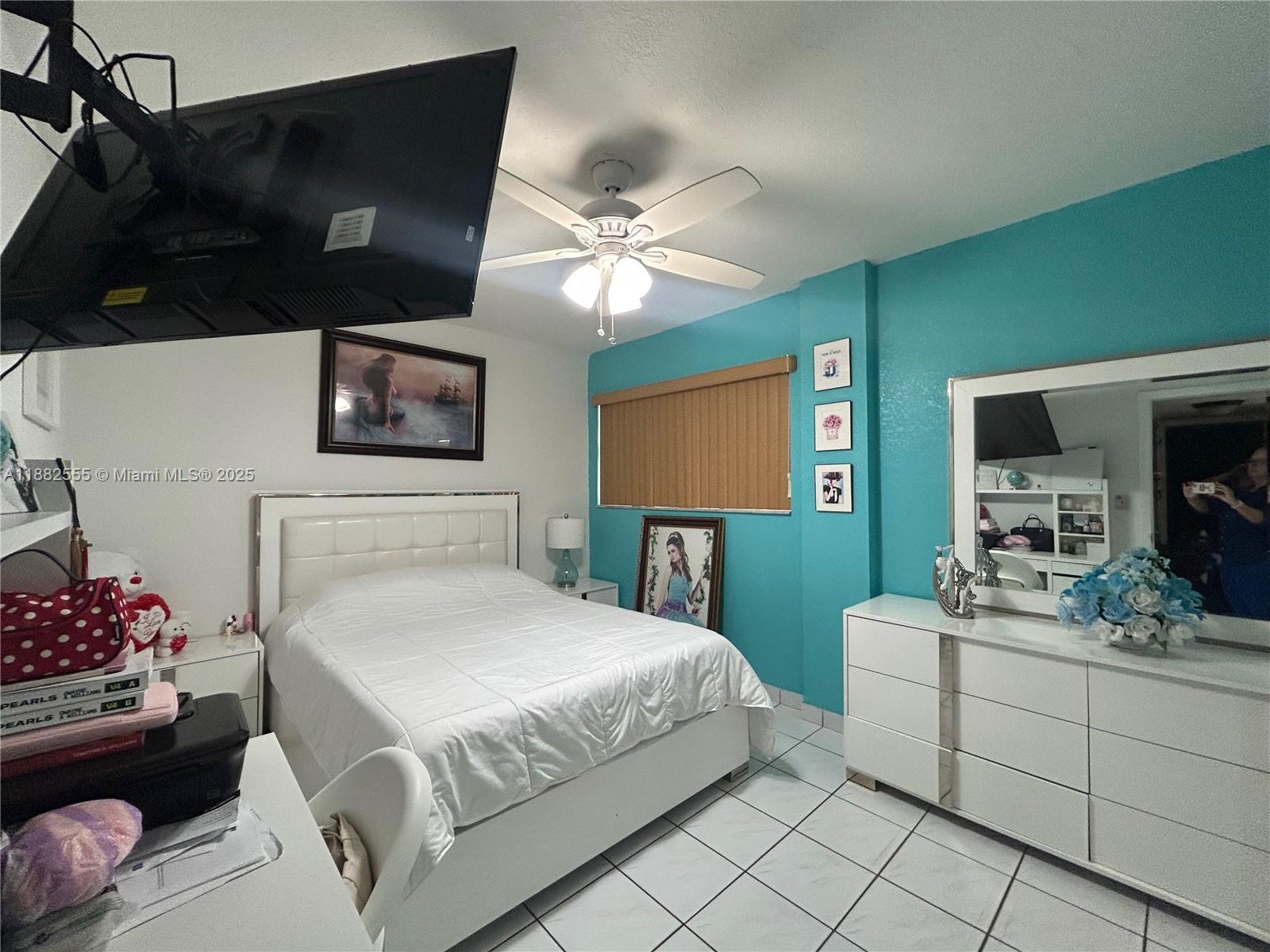 460 East 23rd Street, Unit 103 Hialeah, FL 33013 - Photo 9 of 20 a bedroom with a bed and a flat screen tv