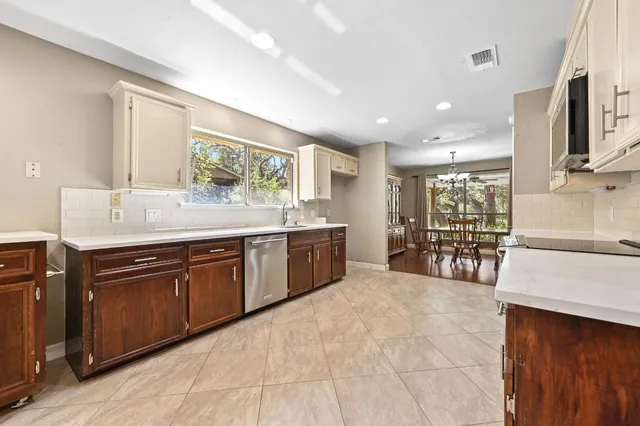 a large kitchen with stainless steel appliances granite countertop a sink and cabinets