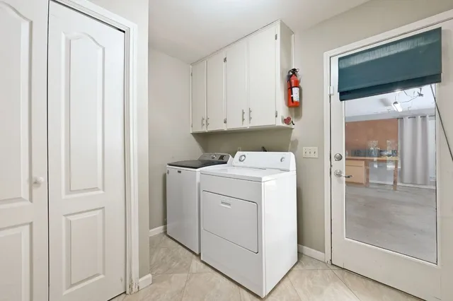 a utility room with cabinets washer and dryer