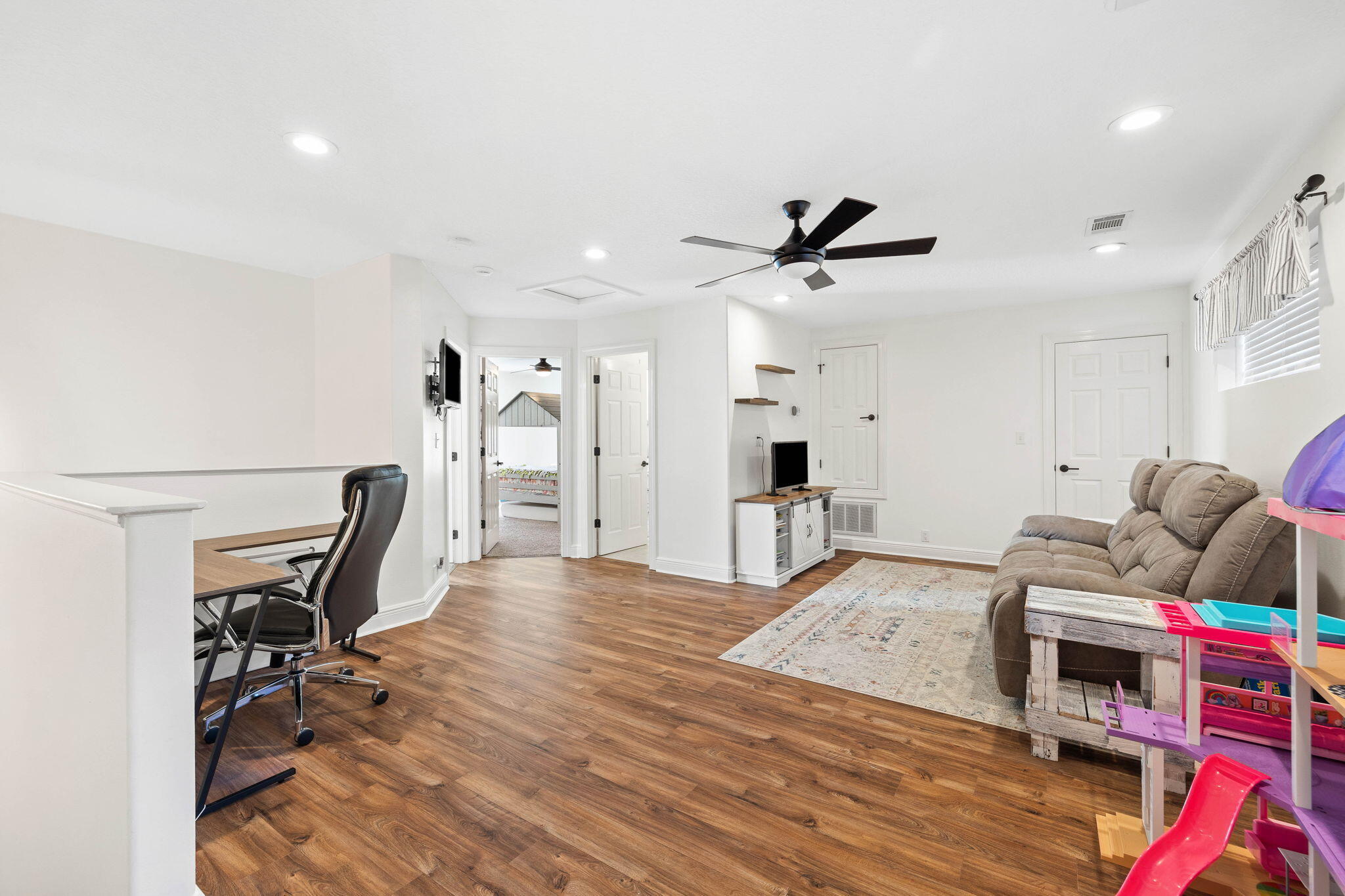 201 Mattie's Way Destin, FL 32541 - Photo 28 of 61 a living room with furniture and a wooden floor