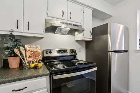 a kitchen with stainless steel appliances granite countertop a refrigerator and a sink