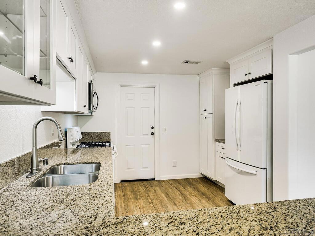 1718 Tecalote Drive, Unit 14 Fallbrook, CA 92028 - Photo 13 of 40 a kitchen with granite countertop a refrigerator and a sink