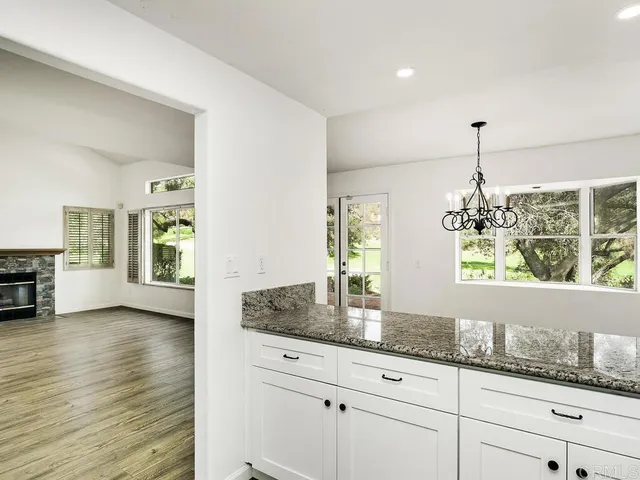 a kitchen with granite countertop white cabinets and appliances