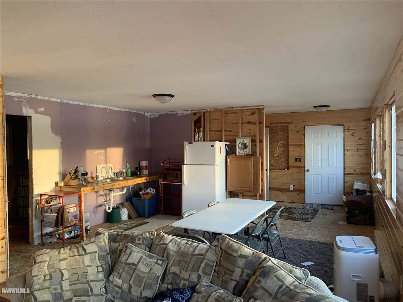 5476 South River Road Hanover, IL 61041 - Photo 12 of 17 a bed room with a bed furniture and a kitchen view