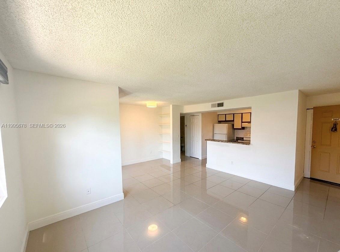 1253 Southwest 46th Avenue, Unit 1608 Pompano Beach, FL 33069 - Photo 4 of 14 a view of an empty room with a window