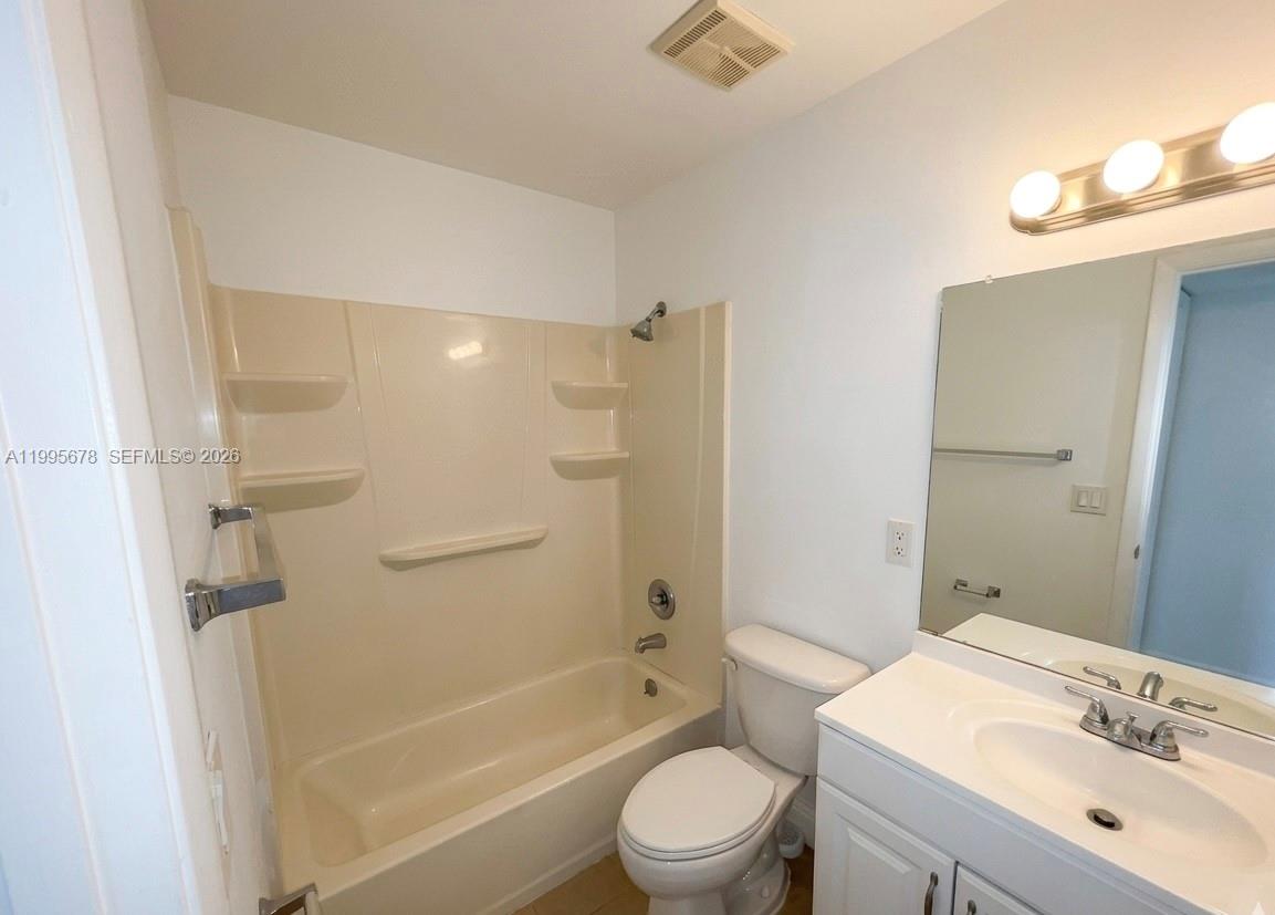 1253 Southwest 46th Avenue, Unit 1608 Pompano Beach, FL 33069 - Photo 7 of 14 a bathroom with a bathtub shower sink vanity mirror and toilet