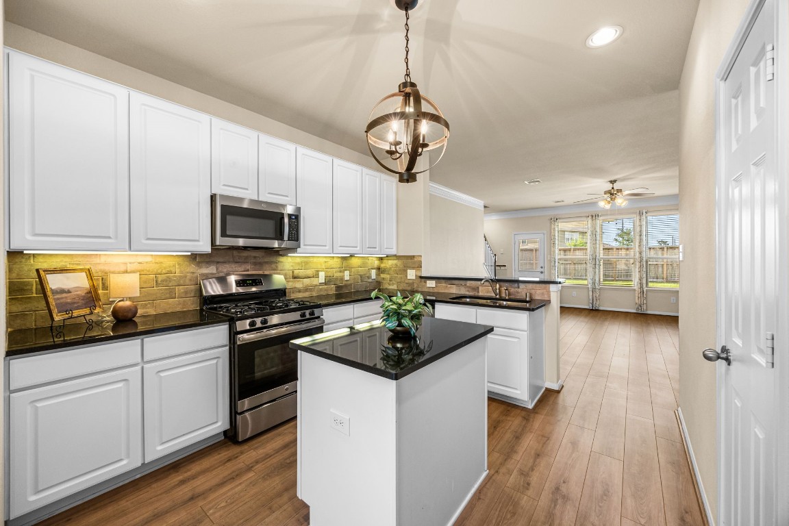 2922 Coachmaker Trail Rosenberg, TX 77471 - Photo 7 of 29 Beautiful island kitchen with white cabinetry, granite countertops, and under cabinet lighting.