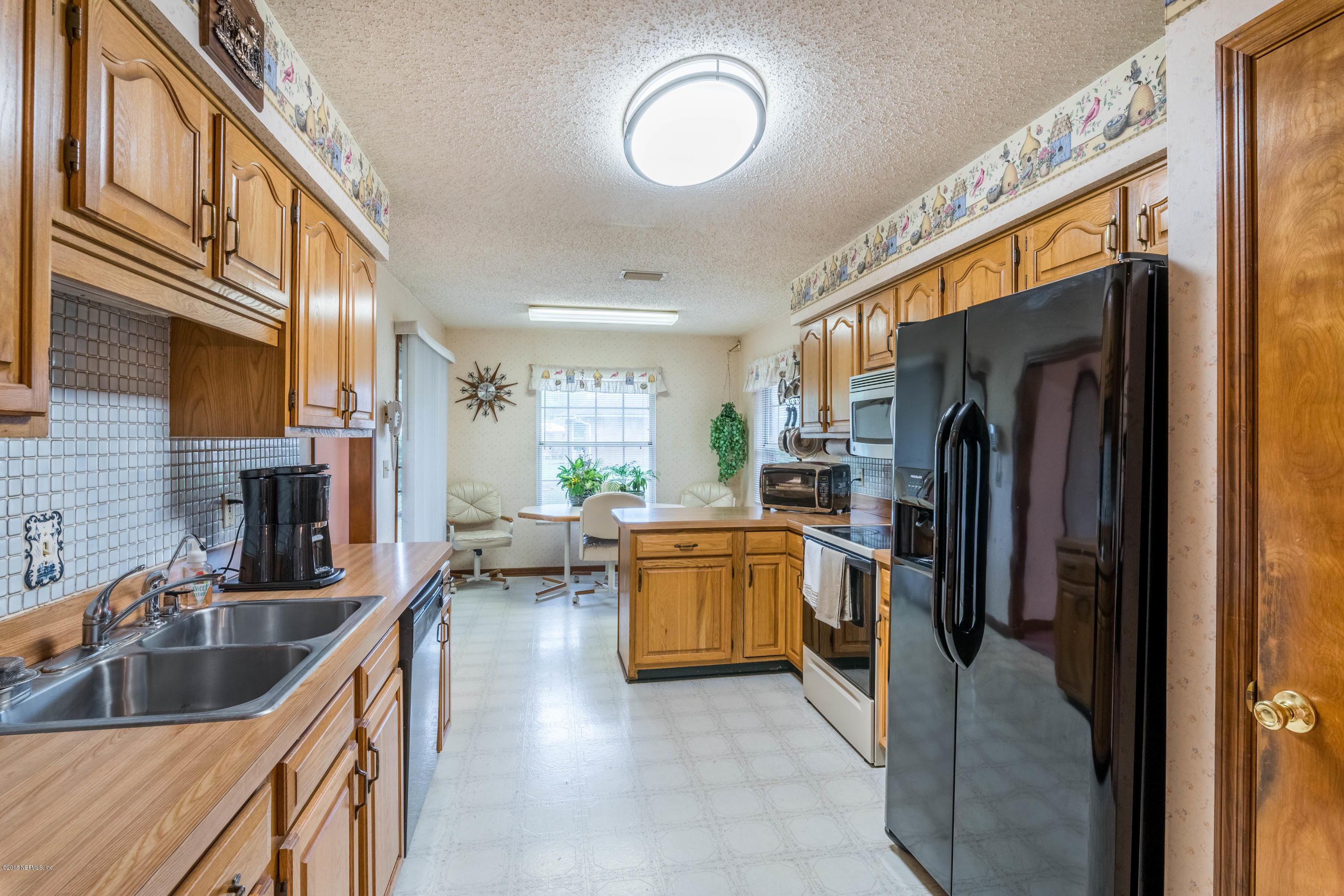 55452 Deer Run Road Callahan, FL 32011 - Photo 8 of 28 a kitchen with lot of cabinets and black stainless steel appliances