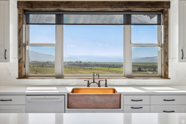 6117 North Rocky Ridge Road Peoa, UT 84061 - Photo 44 of 82 Kitchen window featuring a copper farmhouse sink, bronze-finish faucet, and white subway tile backsplash