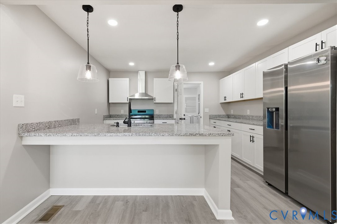 5306 Sterling Road Petersburg, VA 23803 - Photo 7 of 39 a kitchen with stainless steel appliances granite countertop a sink a refrigerator a oven and white cabinets with wooden floor