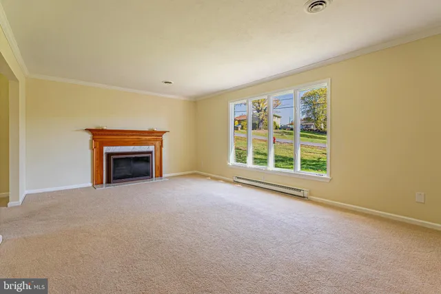 an empty room with windows a fireplace and a window