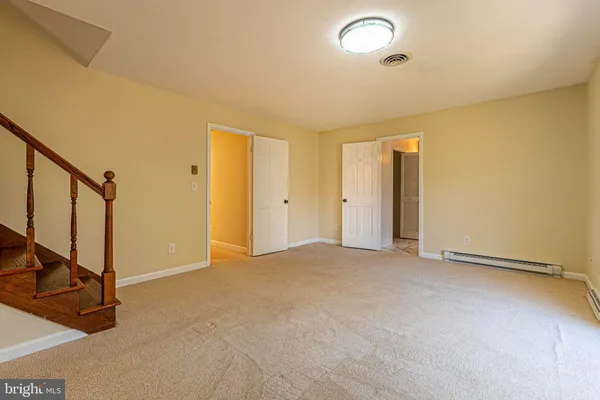 an empty room with staircase and door