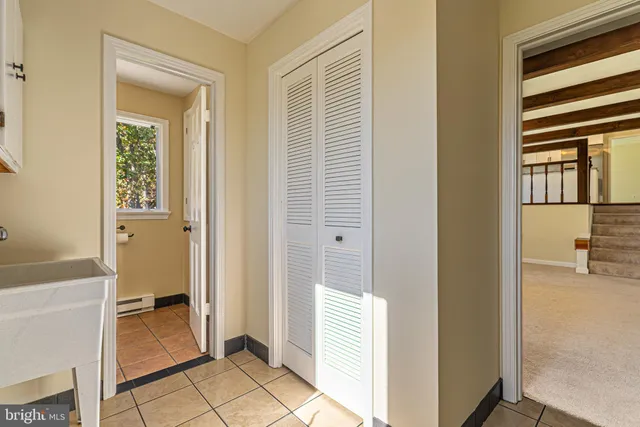 a view of a hallway with bathroom and sink
