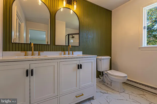 a bathroom with a toilet sink and mirror