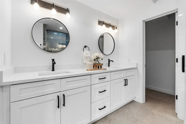 a bathroom with a double vanity sink and a mirror