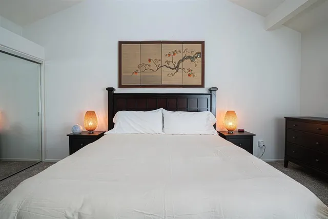 a bedroom with a bed and painting on the wall