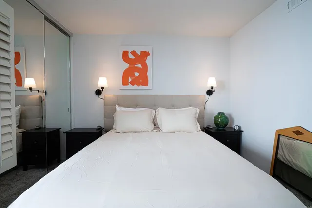 a bedroom with a bed and a painting on the wall