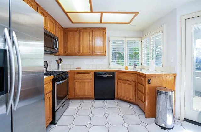 a kitchen with stainless steel appliances granite countertop a stove a sink and a refrigerator