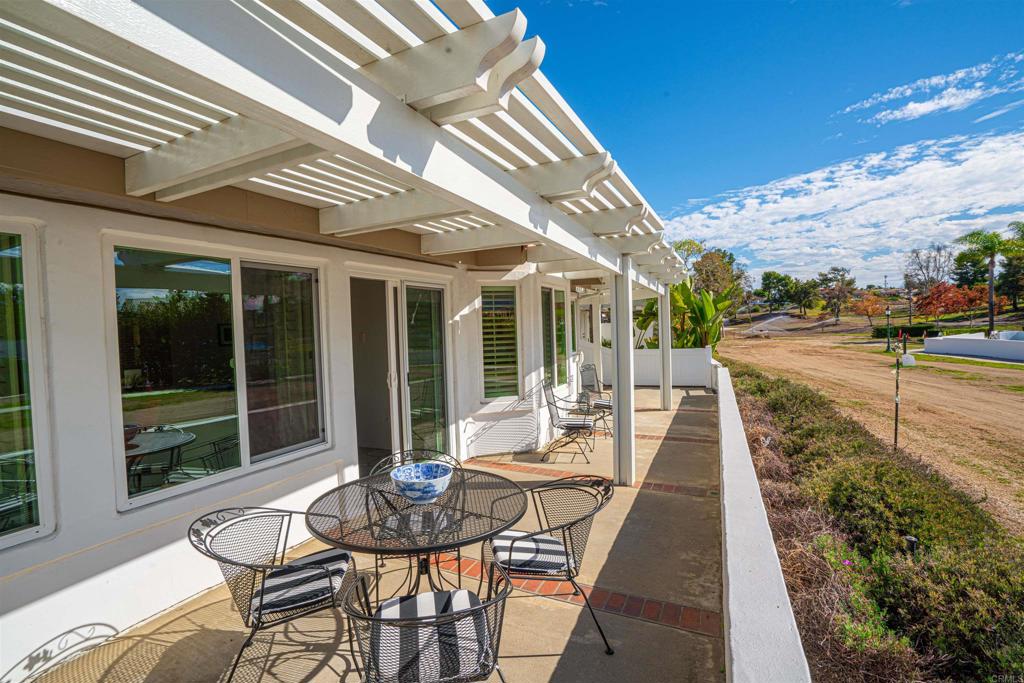 4717 Majorca Way Oceanside, CA 92056 - Photo 22 of 33 a view of a patio with table and chairs potted plants with floor to ceiling window