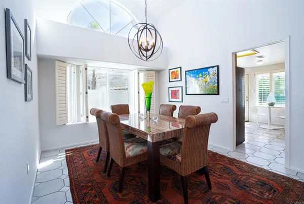a view of a dining room with furniture a chandelier and wooden floor