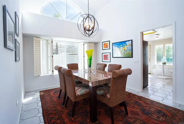 a view of a dining room with furniture a chandelier and wooden floor