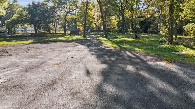 a view of a house with a yard and large trees