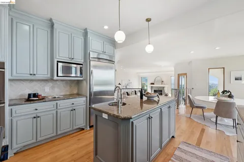a kitchen with a dining table chairs and refrigerator