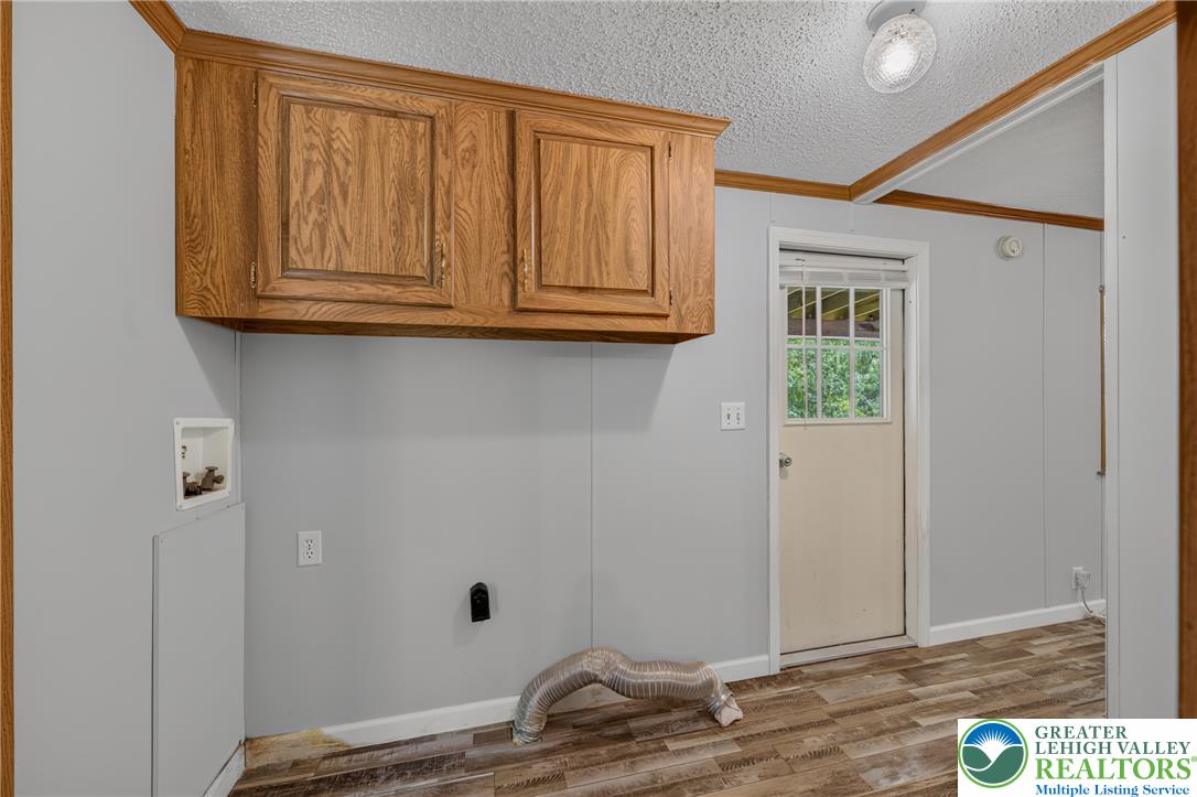 2674 Williams Road Danielsville, PA 18038 - Photo 20 of 31 Functional laundry space with overhead cabinetry and direct outdoor access.