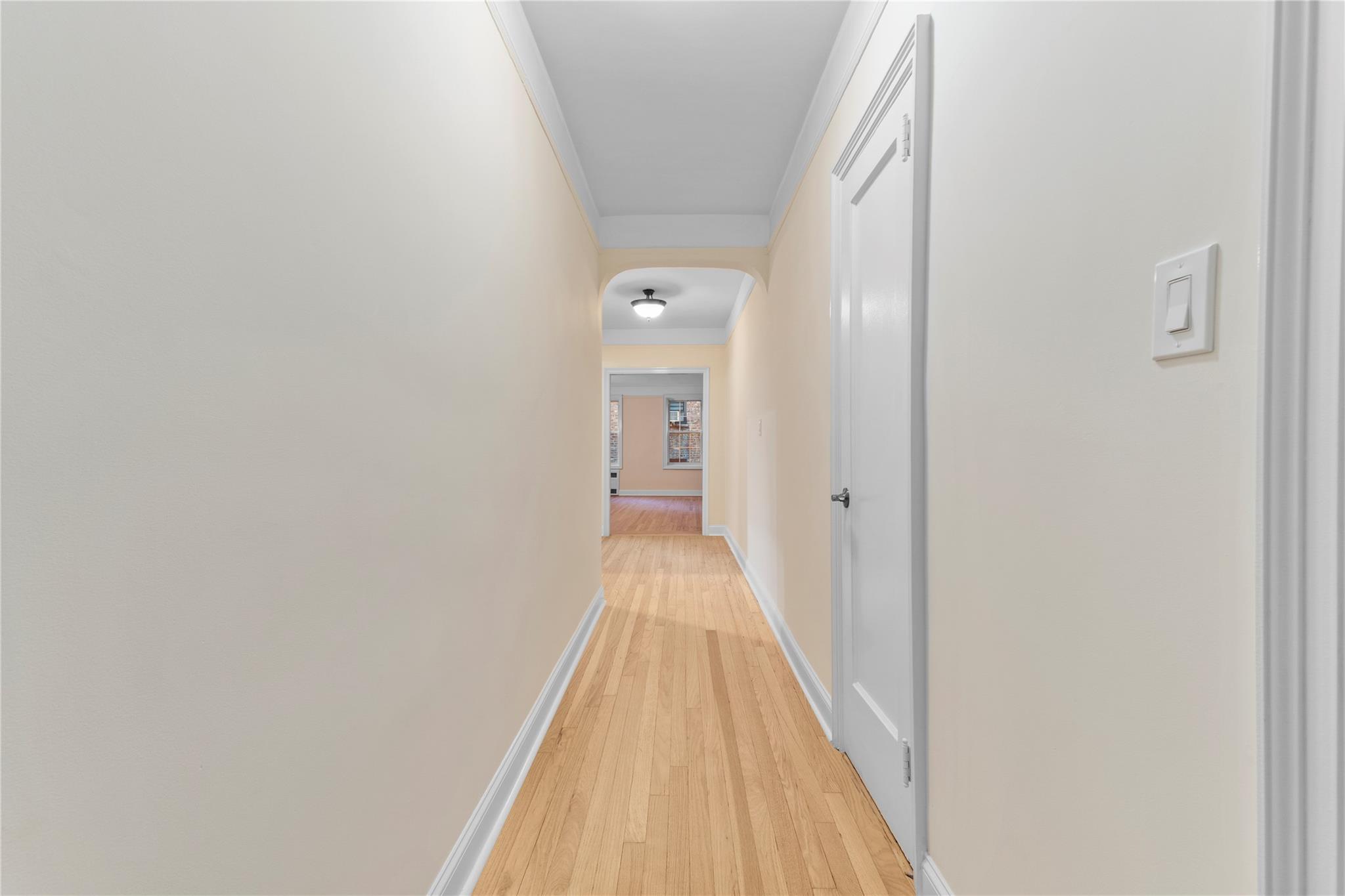 110-07 73rd Road, Unit 4D Queens, NY 11375 - Photo 7 of 16 Corridor featuring ornamental molding, light wood-style flooring, and baseboards