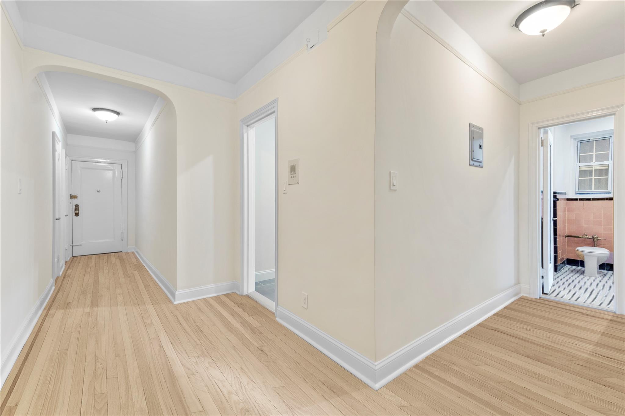 110-07 73rd Road, Unit 4D Queens, NY 11375 - Photo 8 of 16 Hall featuring light wood-style flooring, baseboards, and arched walkways