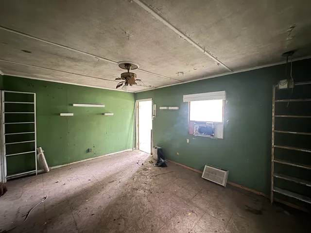 an empty room with closet and windows