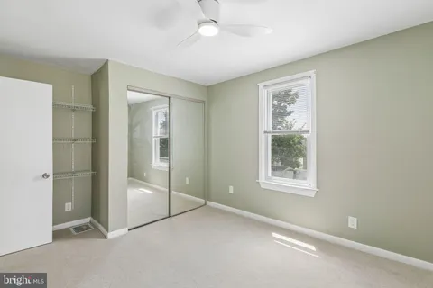 a view of an empty room with window and closet area