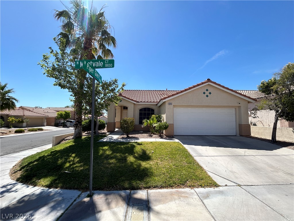 1840 Montvale Las Vegas, NV 89134 - Photo 1 of 31 A terracotta-tiled roof crowns this charming residence, featuring a well-maintained driveway and lush green landscaping.