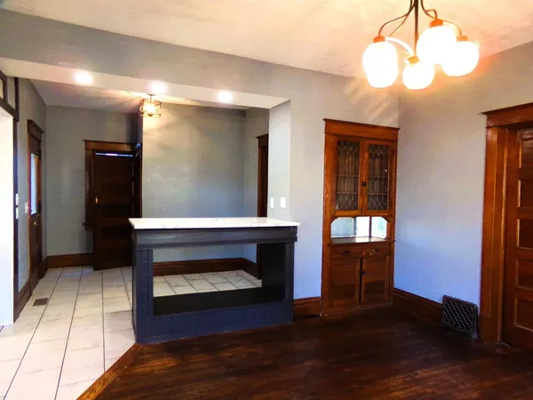 a living room with wooden floor and a fireplace