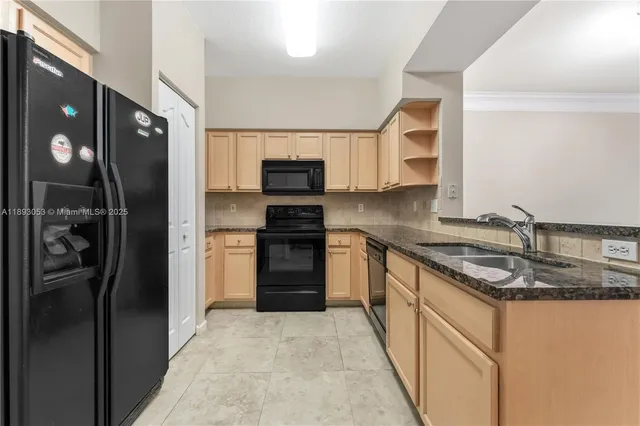 a kitchen with stainless steel appliances granite countertop a refrigerator and a sink