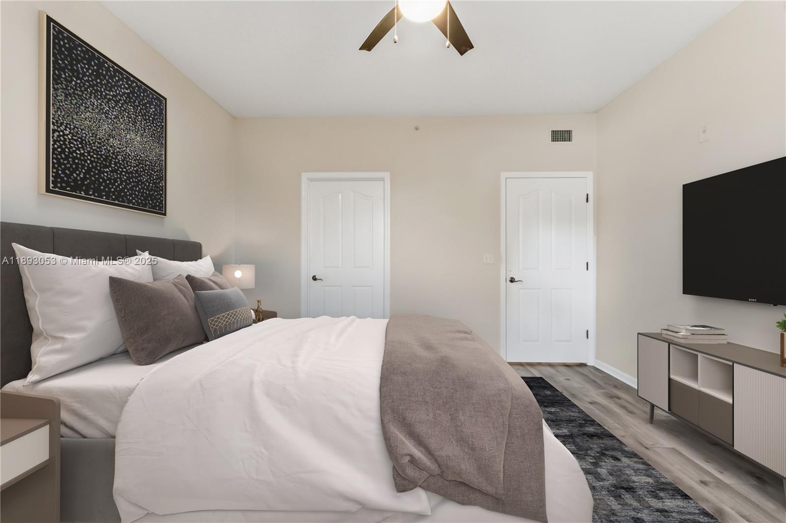 275 Murcia Drive, Unit 104 Jupiter, FL 33458 - Photo 10 of 26 a bedroom with a bed and a flat screen tv