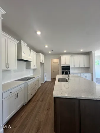 a kitchen with a sink cabinets and wooden floor