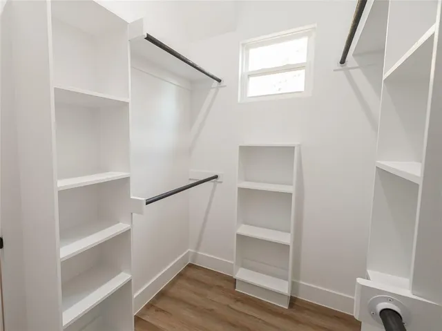 a view of walk in closet with empty racks