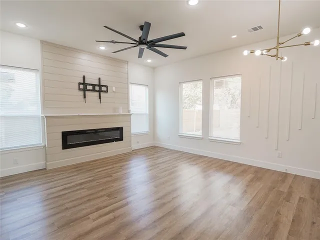 a view of a livingroom with a ceiling fan a fireplace and wooden floor