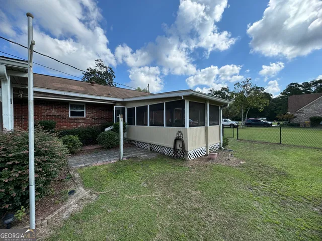 a view of a house with backyard and sitting area