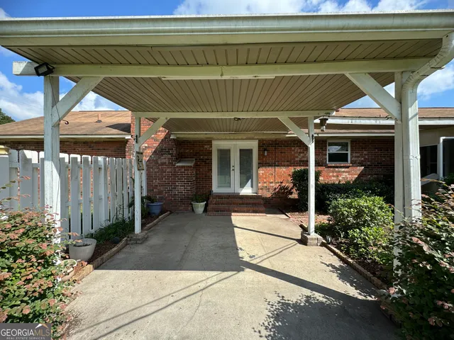 a backyard of a house with plants and wooden fence