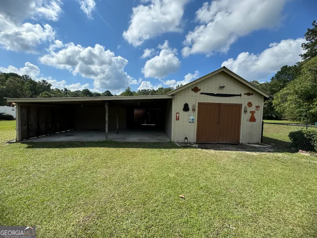 a view of a big yard with plants and large trees