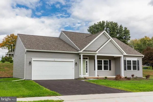 a front view of a house with a garden and yard