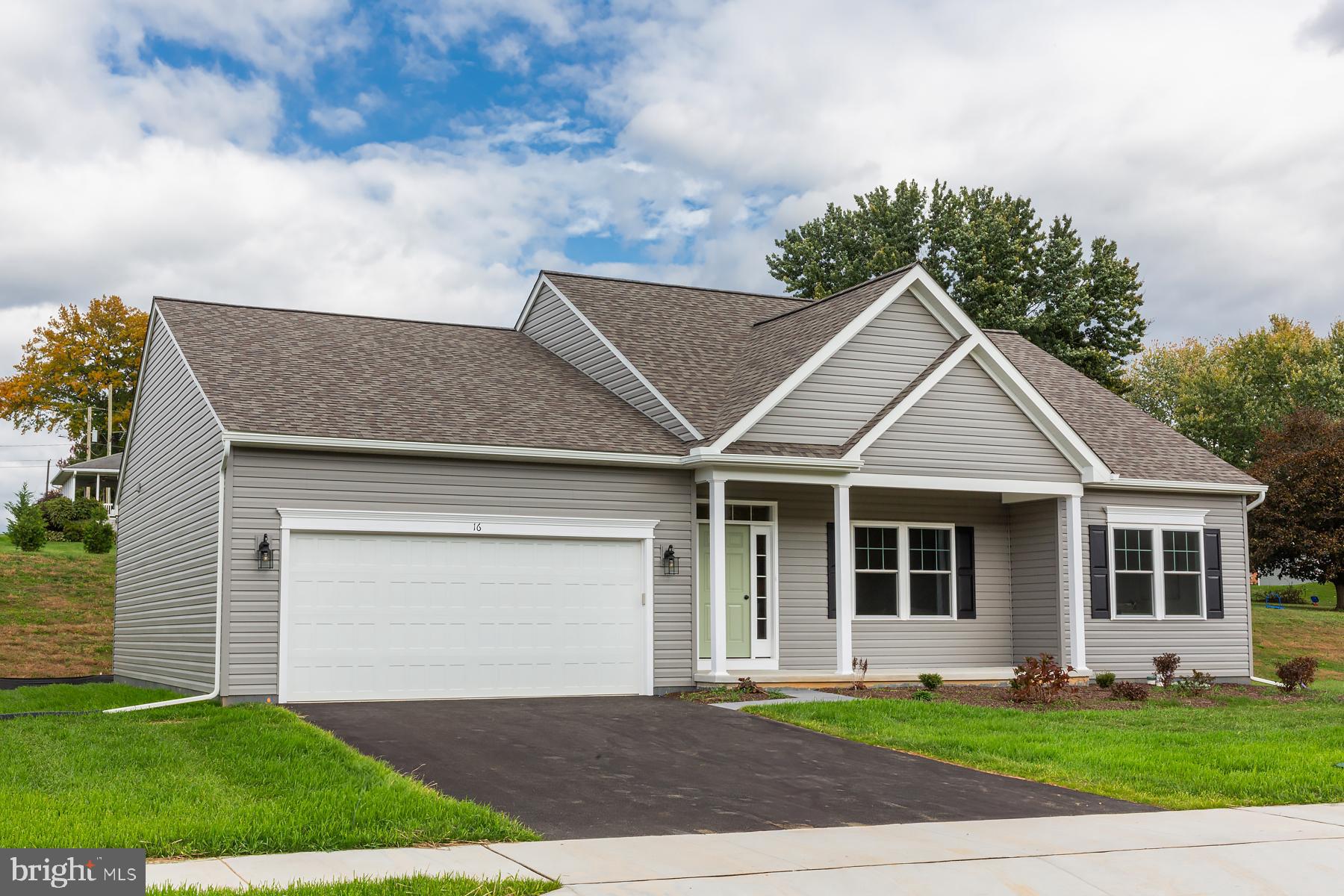 a front view of a house with a garden and yard
